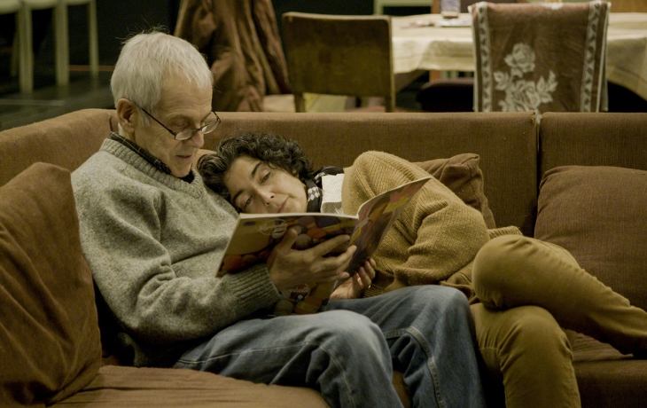 Couple sur le canapé en train de regarder un livre