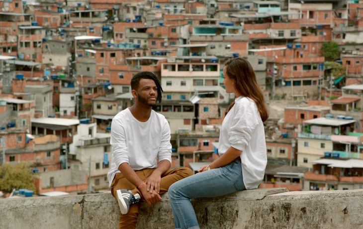 Homme discutant avec une femme au sommet d'une ville avec énormément de batiments.