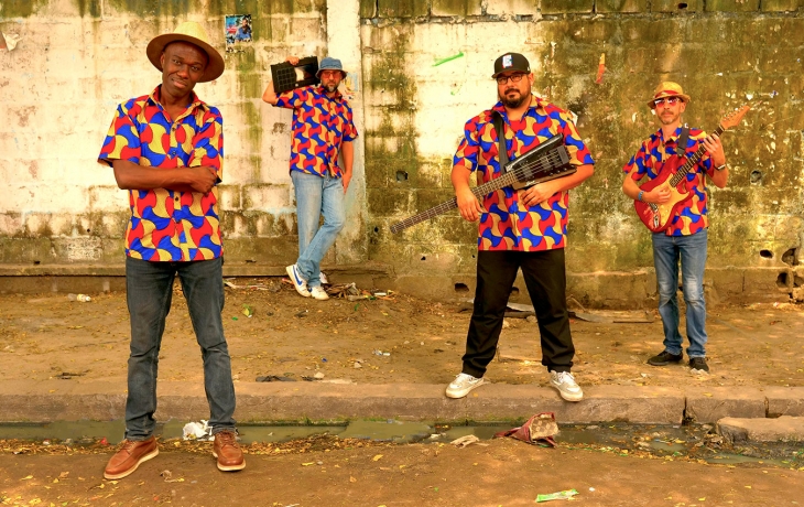 Quatre musiciens en chemise colorées qui regardent l'objectif.