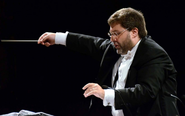 Vito Clemente de profil, en costume en chef d'orchestre