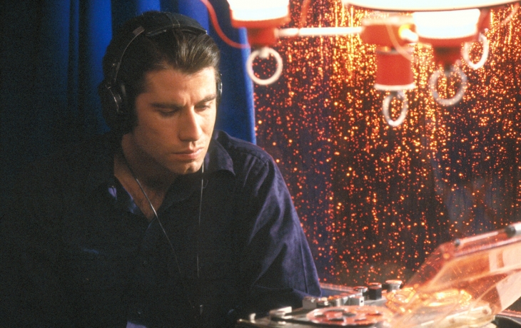 John Travolta dans un café à écouter quelque chose