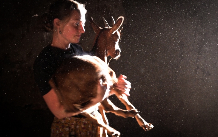 Femme agricultrice qui porte une chèvre