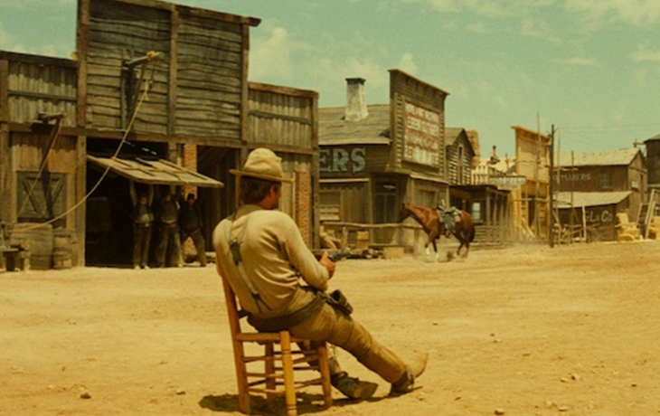 Un homme dans une ville déserte, assis sur une chaise
