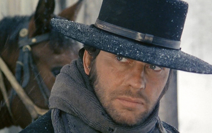 Un homme sous la neige avec son cheval 