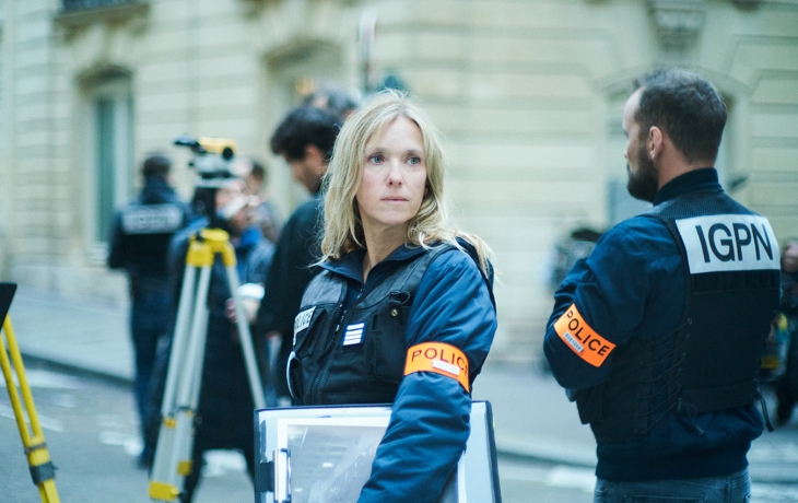 Femme policière dans la rue entourée de ses collègues