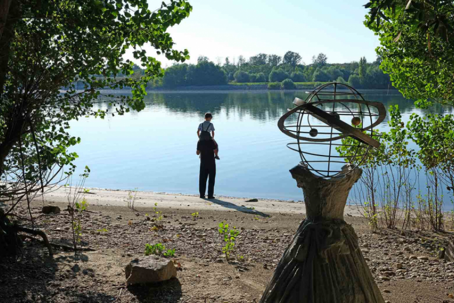 Anselm. Homme regardant le lac avec en premier plan une sculpture d'une robe