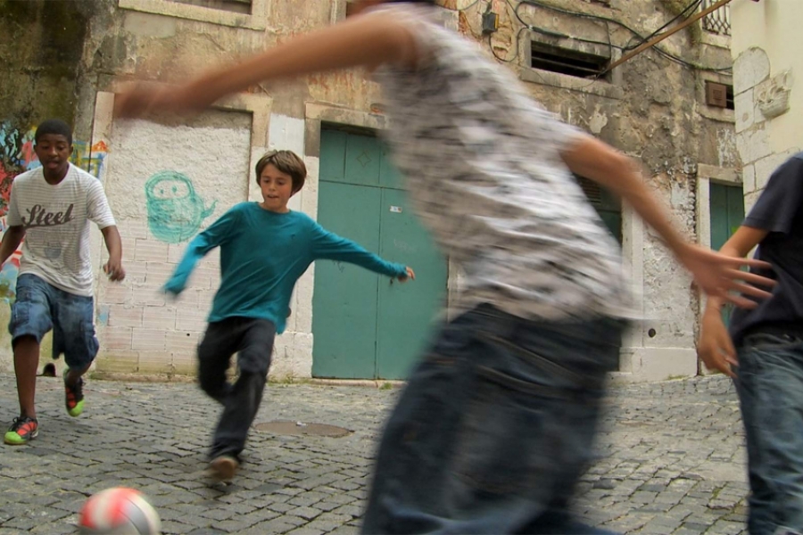 Garçons jouent au foot dans la rue