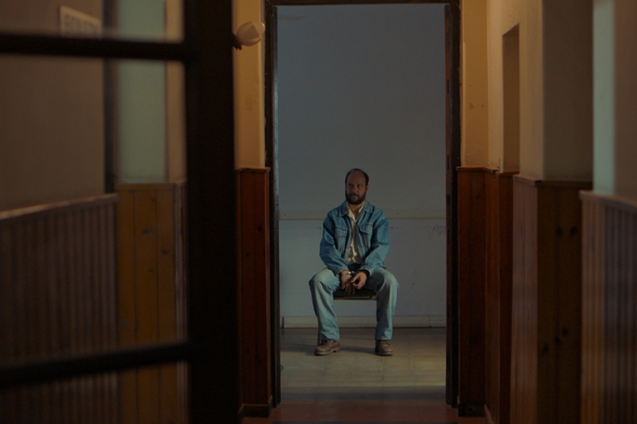 Homme assis sur une chaise au fond d'un couloir