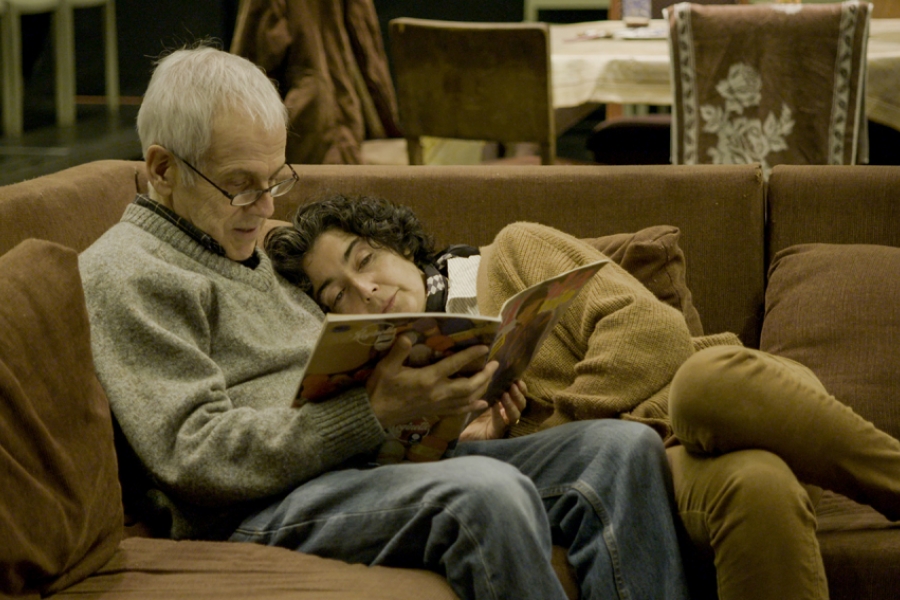 Couple sur le canapé en train de regarder un livre