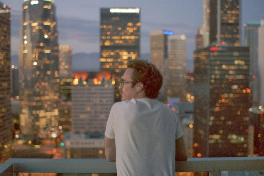 Homme avec une oreillette devant un paysage urbain.