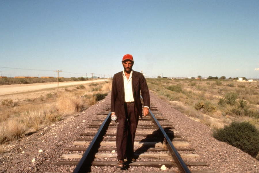 Homme seul marchant sur les railles du train.