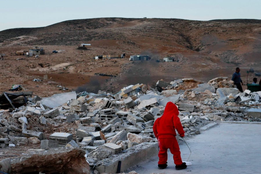 Enfant sur le toit d'une maison, un village en ruine autour