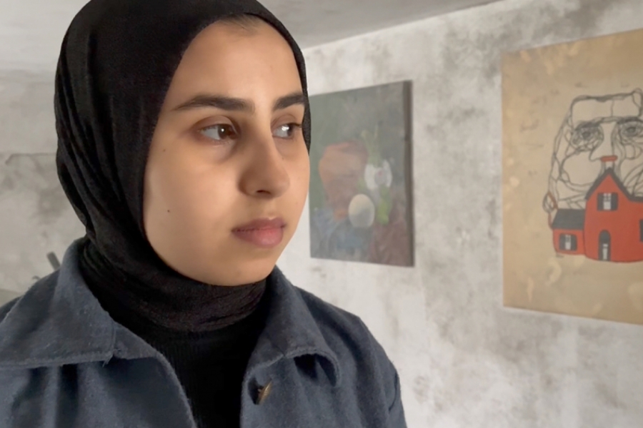 Une jeune fille dans une pièce autour de ses tableaux 