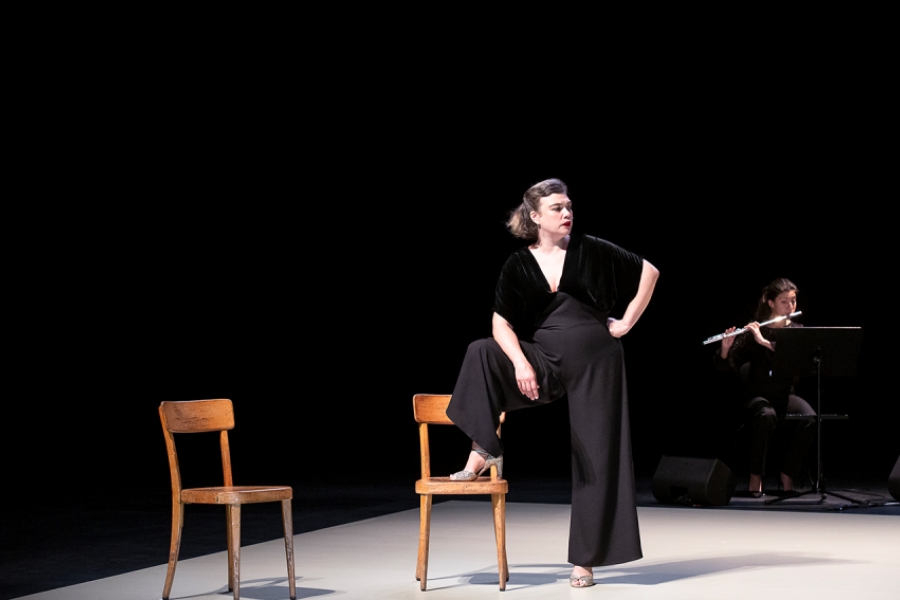 Sur scène, les musiciennes sont à l'arrière plan. Au premier plan il ya RoseMary, un pied sur une chaise en bois.