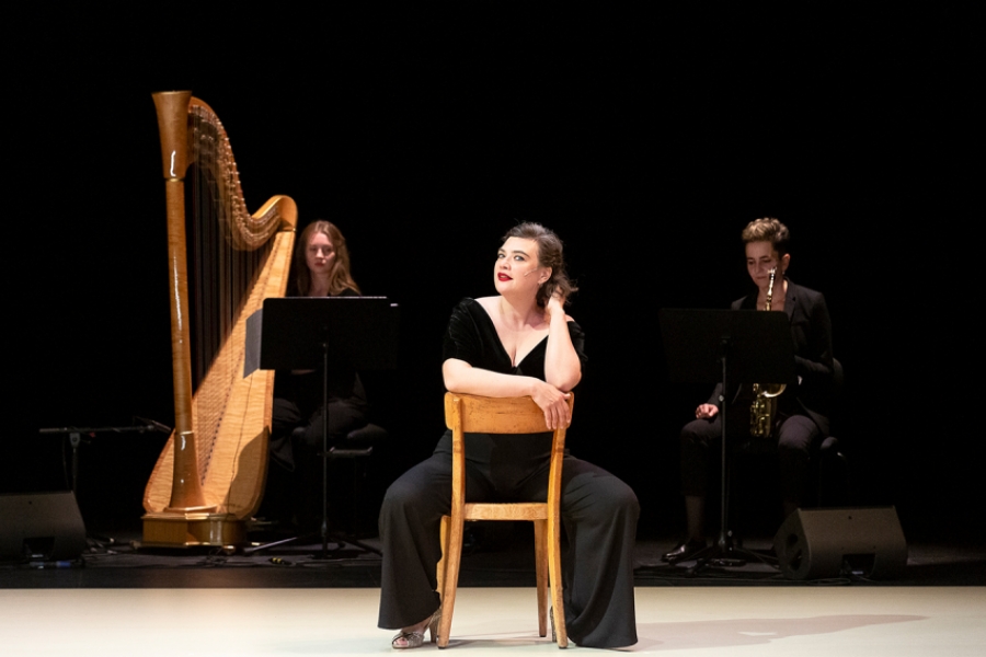 Sur scène, les musiciennes sont à l'arrière plan. Au premier plan il ya RoseMary, assises sur une chaise en bois.
