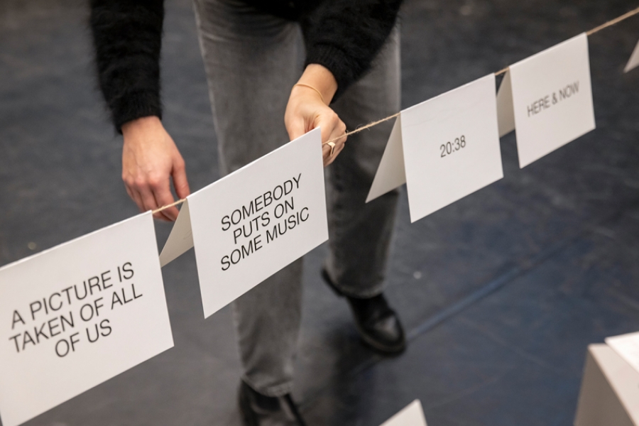 Des feuilles avec des phrases en anglais sont posées les une après les autres sur un fil tendu.