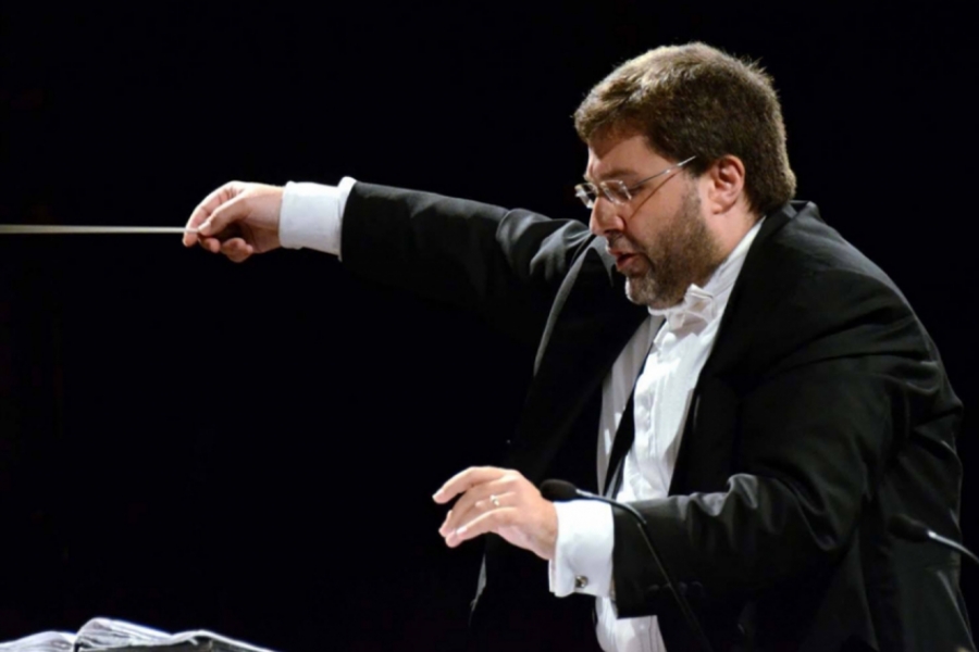 Vito Clemente de profil, en costume en chef d'orchestre