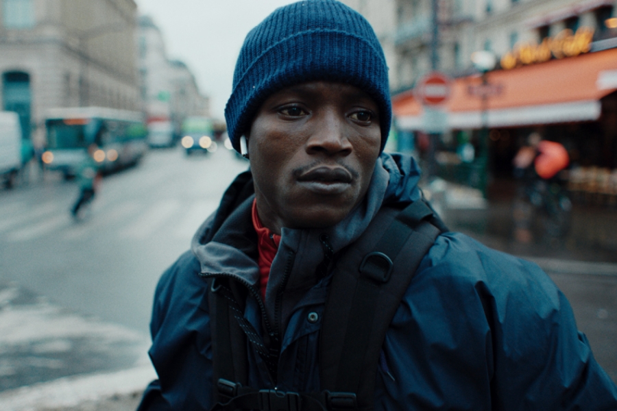 Plan serré sur le visage de Souleymane dans les rues de Paris.
