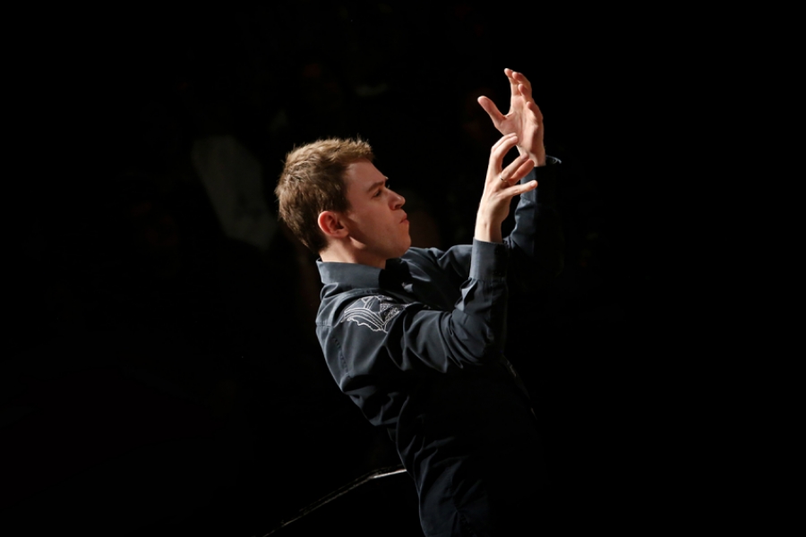 Portrait de Sylvain Gasançon. Il est de profil les mains levées et ouvertes en face de son visage