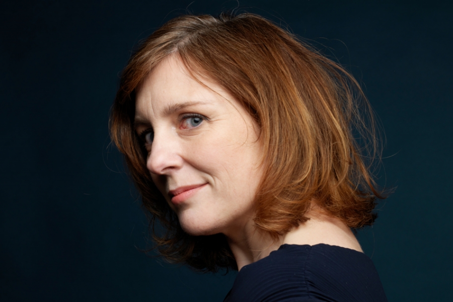 Portrait gros plan d'Anna Wall, la tête de trois quart, sourire aux lèvres.