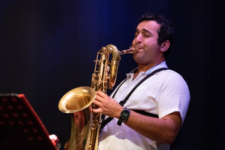 Plan serré sur Sofiane Messabih qui joue du saxophone.