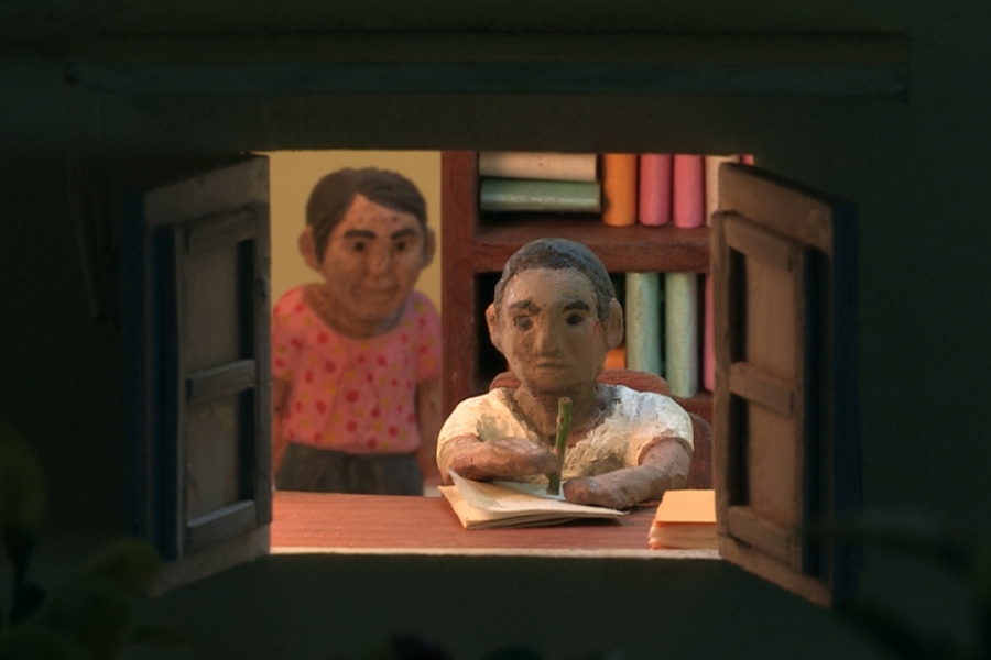 Dans l'encadrement d'une fenêtre, deux petits personnages en argiles. L'un des deux écrit une lettre devant la fenêtre.