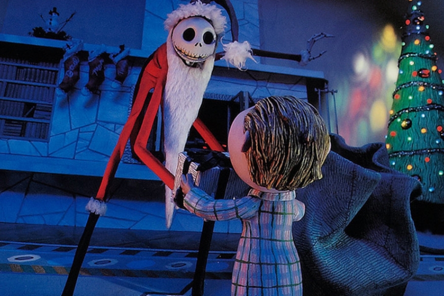Mr Jack habbilé en père noël tient les mains d'un petit garçon au pied du sapin