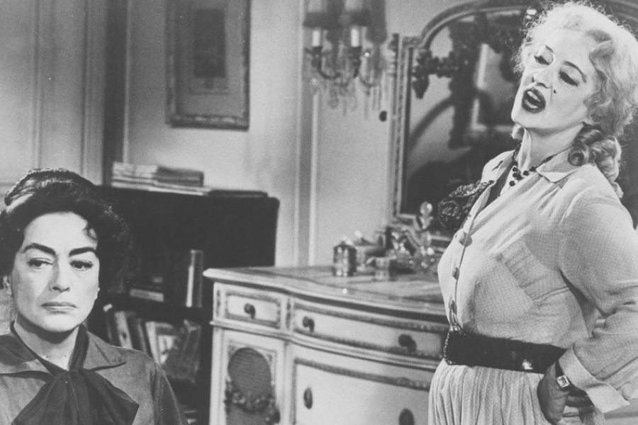 Noir et blanc. Au premier plan à gauche, il y a Blanche. En haut à droite, Baby Jane s'exclame. 