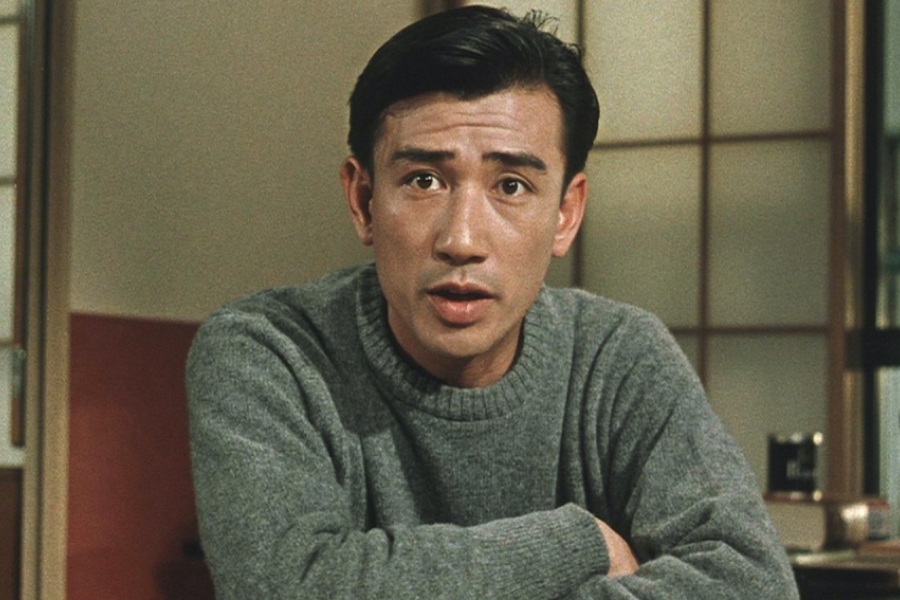 Un homme est attablé, les bras croisés