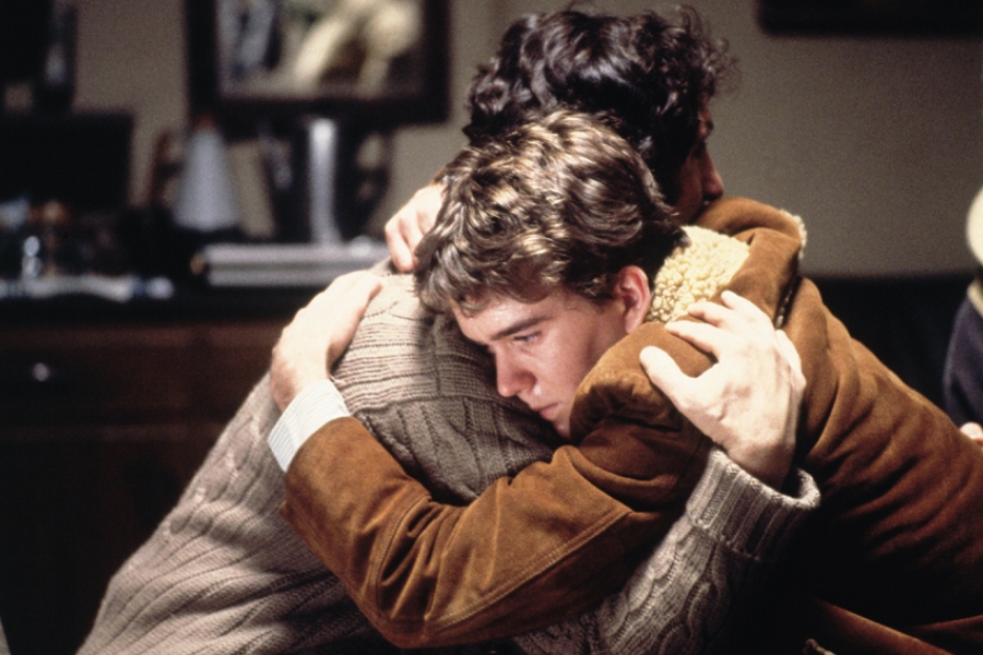 Le jeune garçon prends son père dans ses bras.