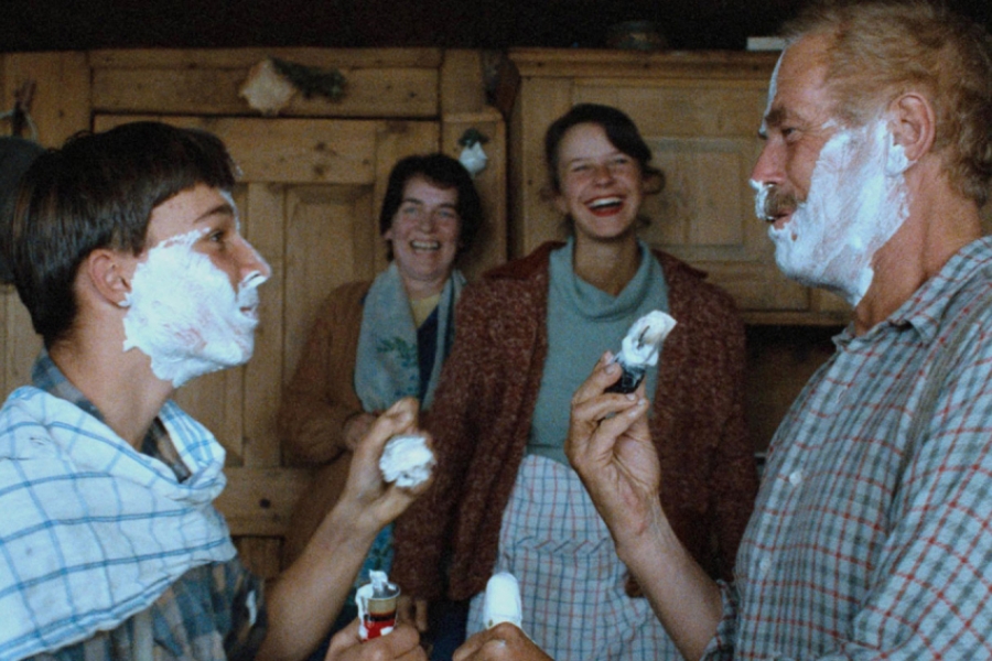 Au premier plan, le père et le Boueb ont de la mousse sur le visage pour se raser. La fille et une dame, à l'arrière plan, les regardent en rigolant.