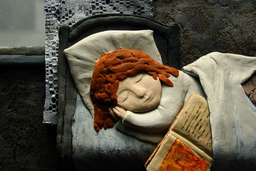 Une petite fille dort dans son lit. Un livre dépasse du lit.