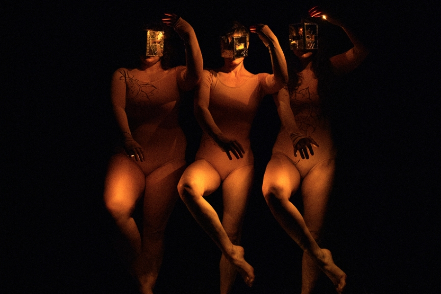 Les 3 interprètes en train de danser avec des masques sur le visage