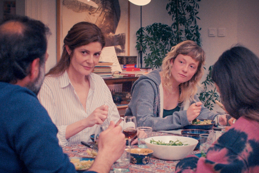 À table, à un repas de famille. Tout le monde se tourne pour regarder l'homme qui est en bout de table.