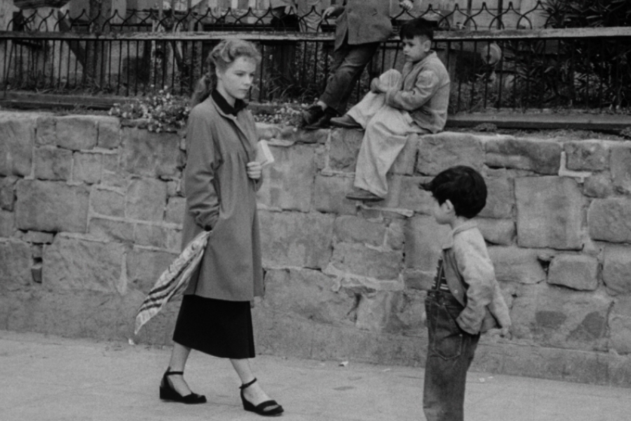 Dans la rue, une femme croise le chemin de deux enfants qui l'interpelent.