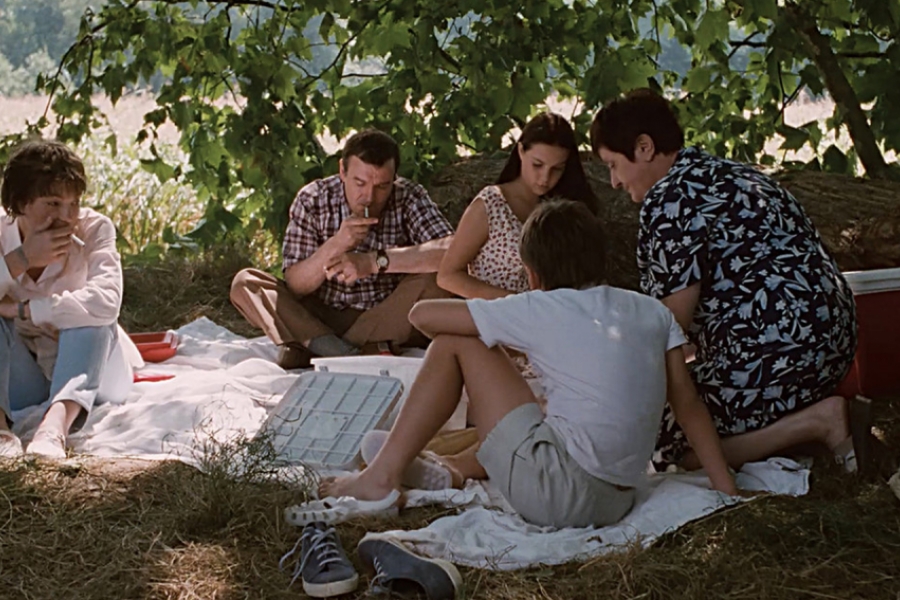 Une famille fait un pique-nique dans la nature.