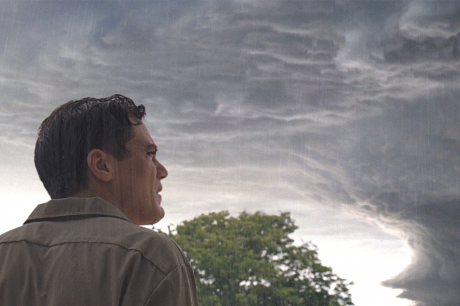 Un homme regarde le ciel qui se prépare à une tempête.
