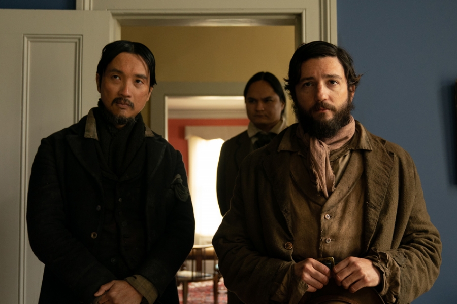 Deux hommes se présentent à quelqu'un qu'on ne voit pas dans le champ. Ils tiennent leurs chapeaux dans leurs mains, comme signe de politesse et de respect. Ils sont dans une maison bourgeoise.