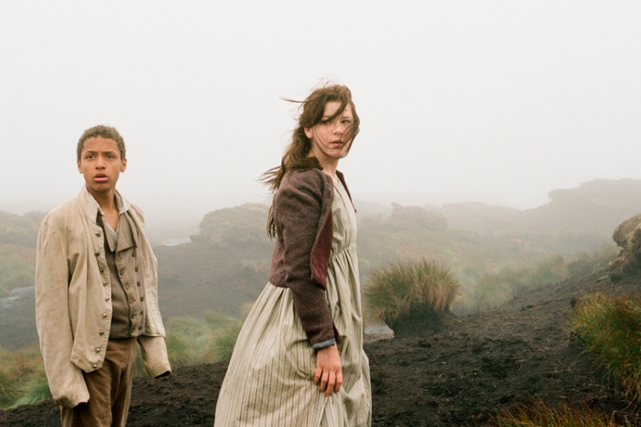 Dans les montagnes, une jeune fille et un jeue garçon se promènent. Les montagnes sont cachées par la brume.