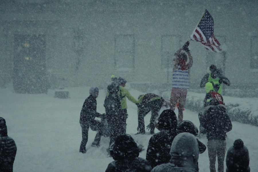 Groupe de personnes dehors, l'un brandissant le drapeau américain