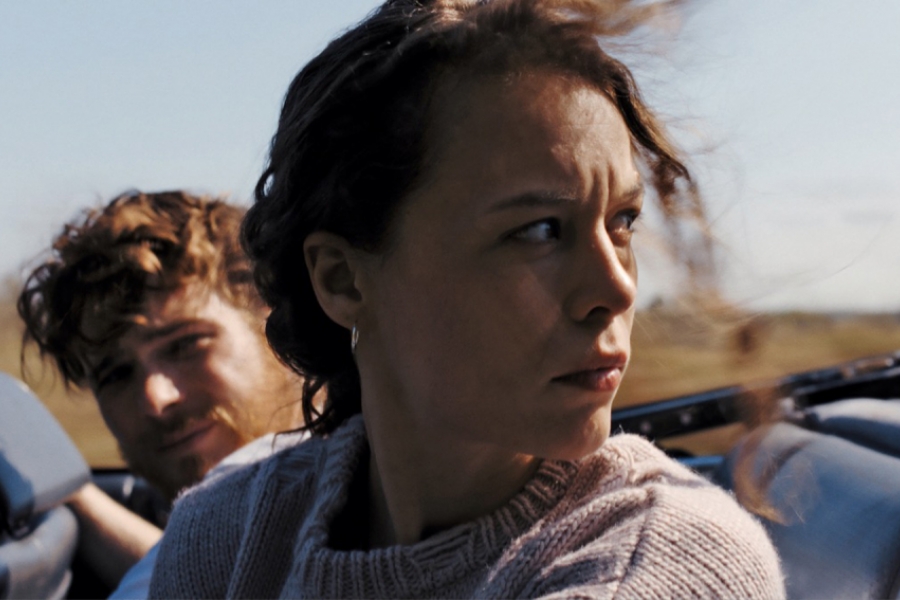 En voiture, une femme à côté d'un homme se retourne, le regard dur