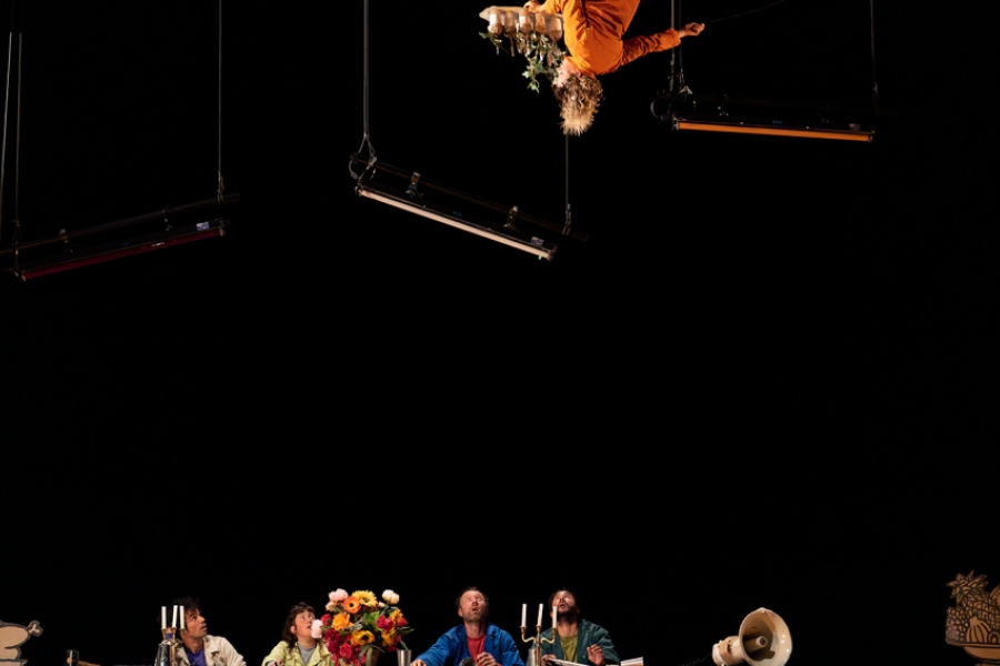 Tous sur une table, les yeux levés sur un acrobate en hauteur