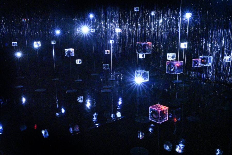 Des cube lumineux sont disposés dans une salle où il fait noir 