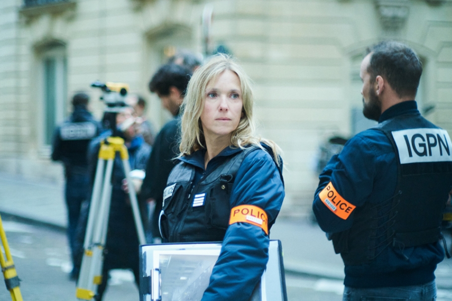 Femme policière dans la rue entourée de ses collègues