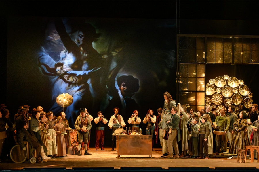 Scène de l'opéra de Dijon où les chanteurs sont en costumes d'époque, "La liberté guidant le Peuple" projetée sur un écran 