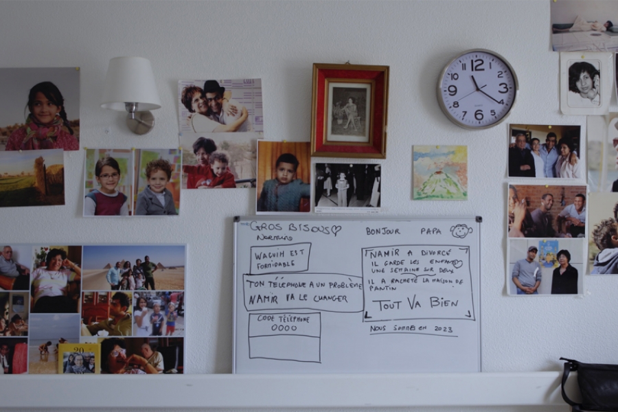 Photo d'un mur avec un tableau et des photos de famille
