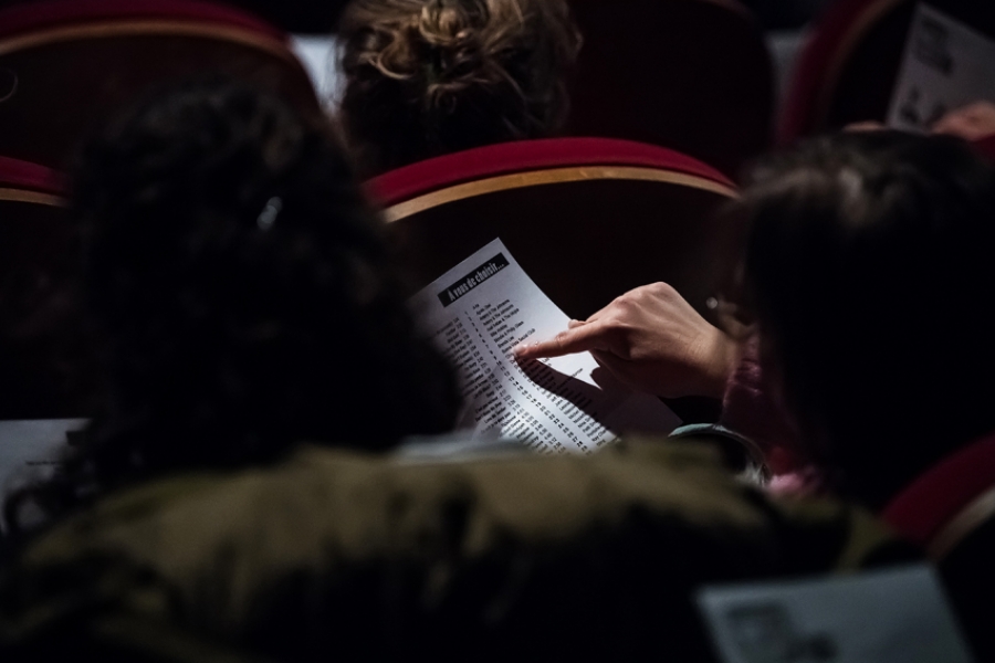 Des personnes du public choisissent parmi un choix de musiques proposées par la Compagnie 