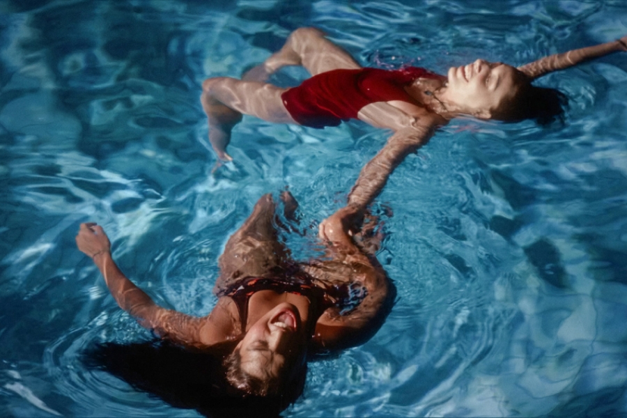 deux filles dans une piscine, sur le dos, main dans la main