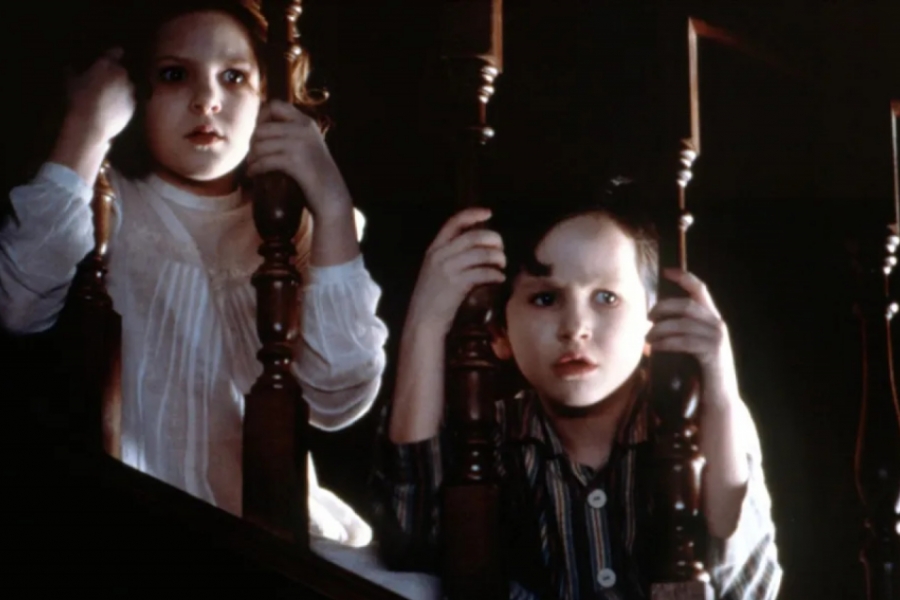 Enfants effrayés regardent à travers les barreaux de l'escalier